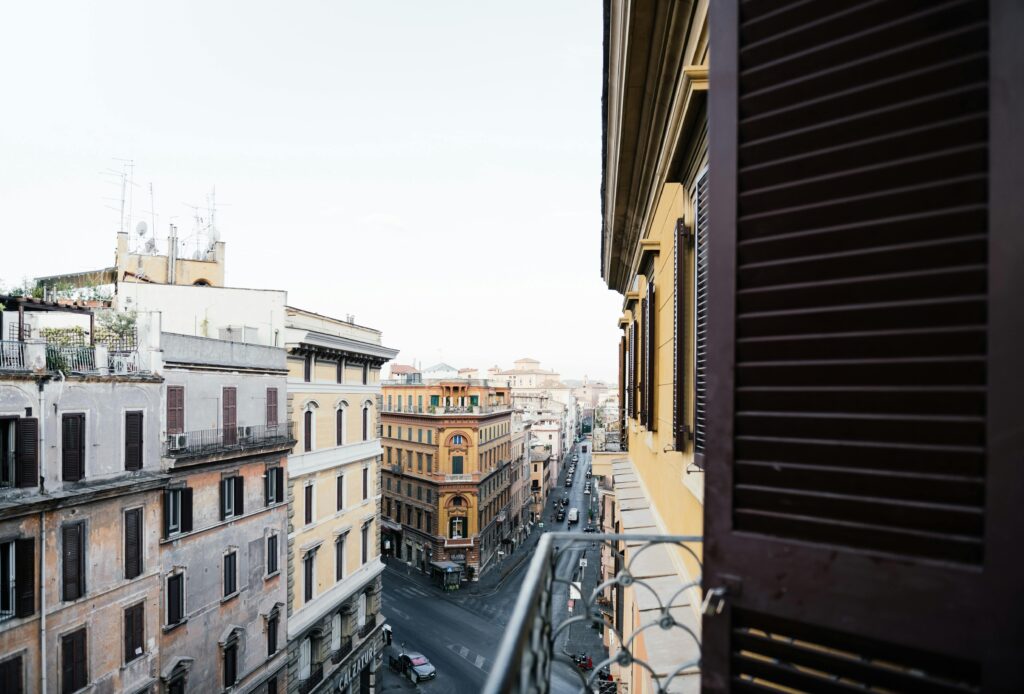 View of urban architecture from a balcony, showcasing historic city streets at daytime.