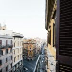 View of urban architecture from a balcony, showcasing historic city streets at daytime.